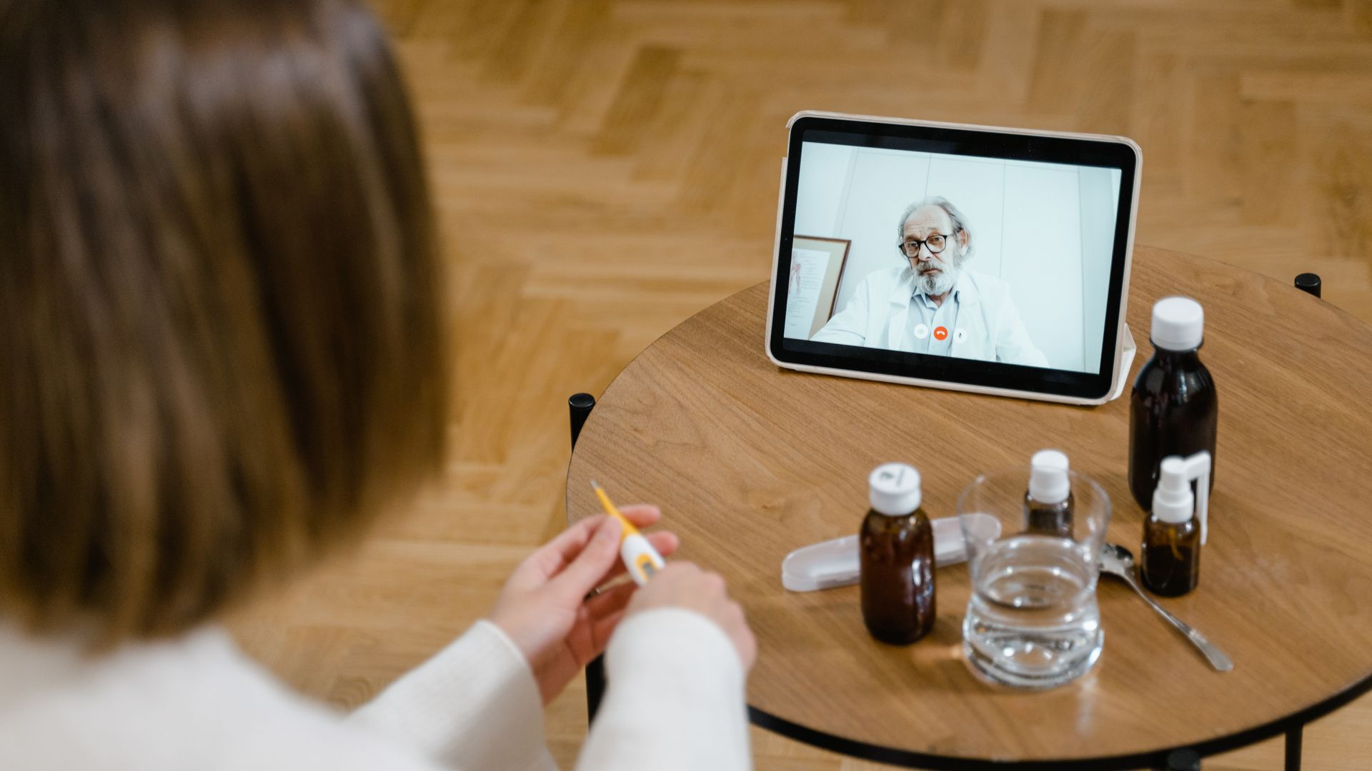 Modafinil Telehealth Prescription Online: Accessing Treatment A doctor provides an online consultation via video call on a tablet, seen on a wooden table — modafinil telehealth prescription online