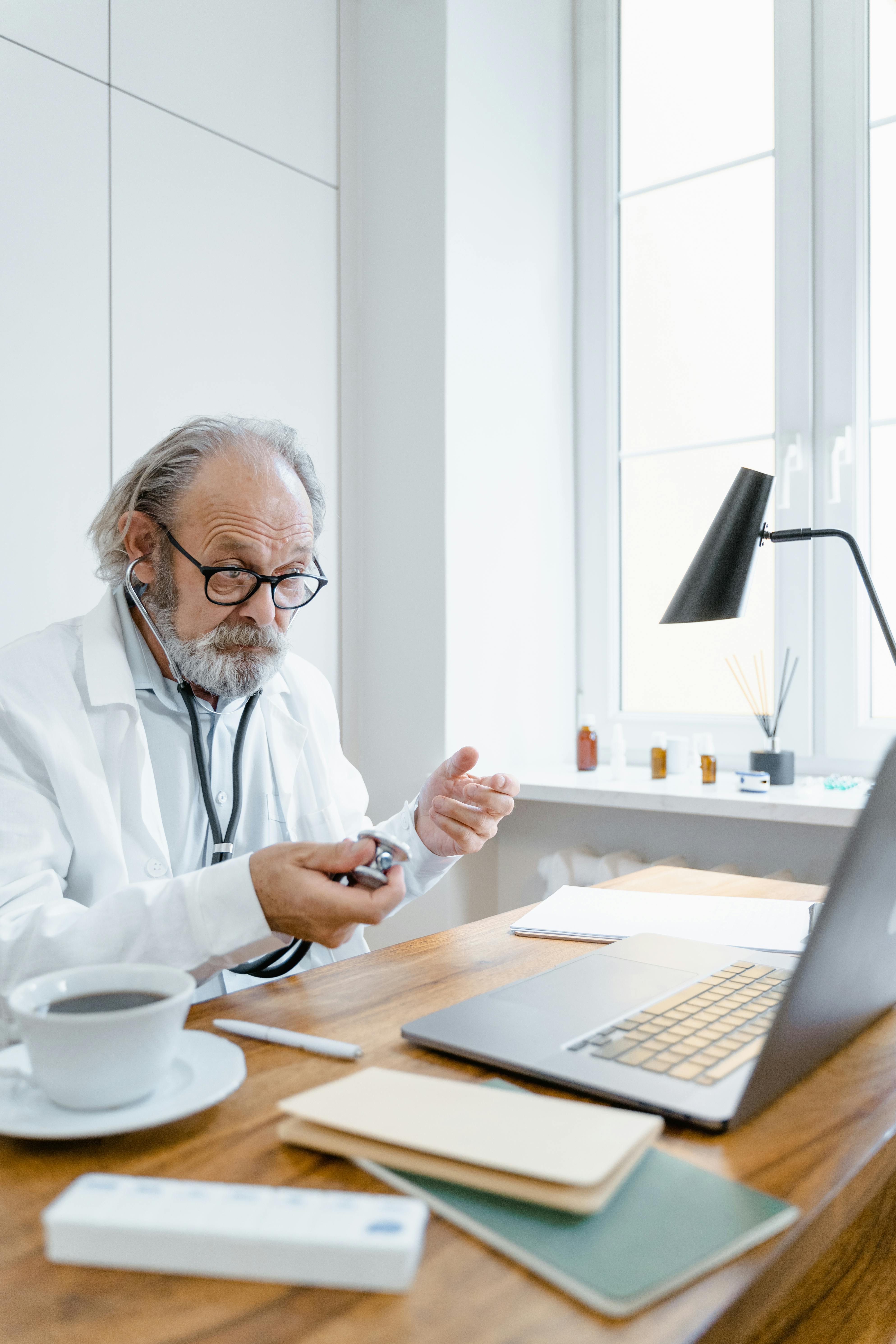 man in white robe holding stethoscope