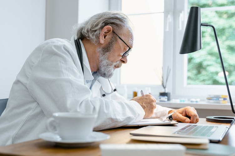 A Doctor Writing On The Paper