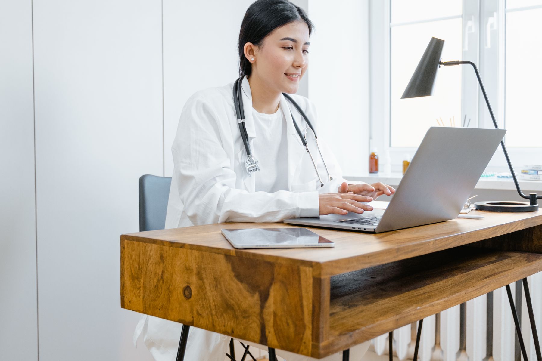 Healthcare professional using a laptop or tablet in a modern practice office