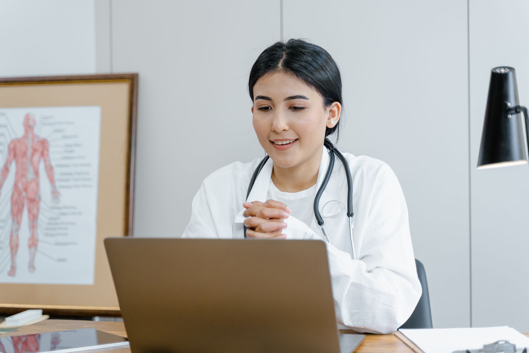 Smiling doctor using a laptop for a remote consultation