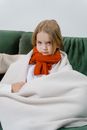 Girl in White Sweater and Red Scarf Sitting on White Sofa
