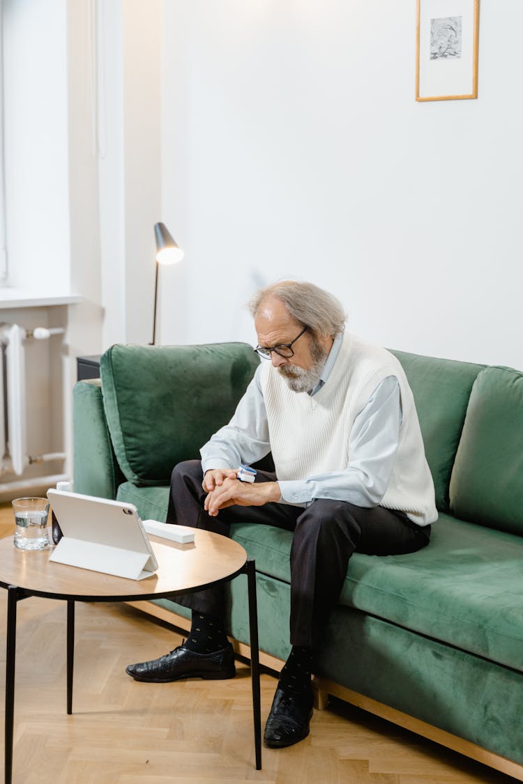 A Sick Man Sitting On The Sofa 