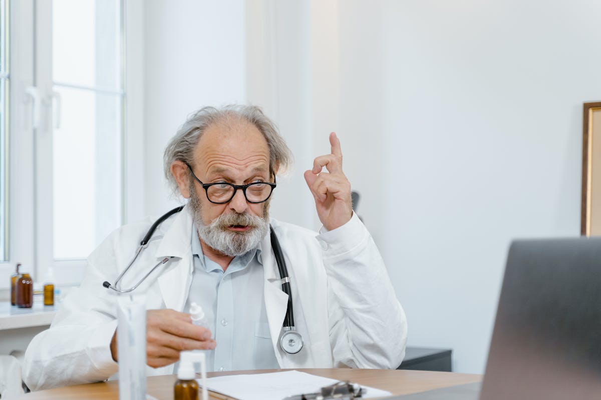 Pediatrician preparing a vaccine while a child sits with a parent