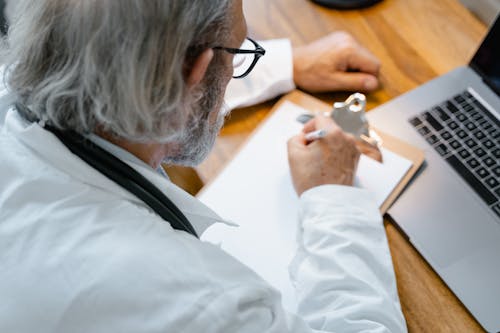 Free A Doctor Writing on a Paper Stock Photo