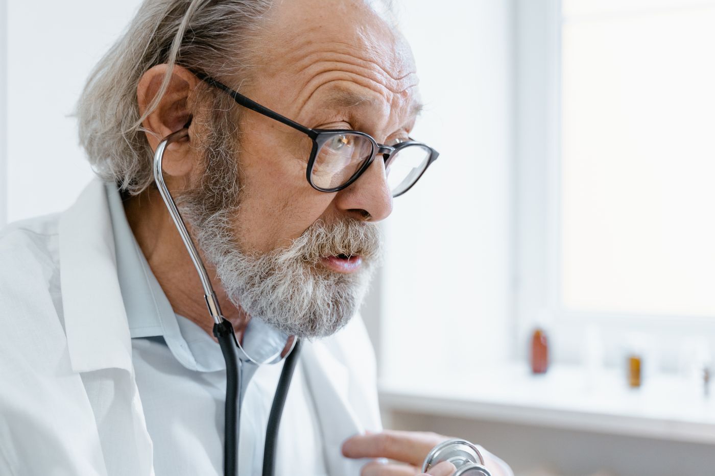Dermatóloga usando un dermatoscopio durante la evaluación de una lesión cutánea