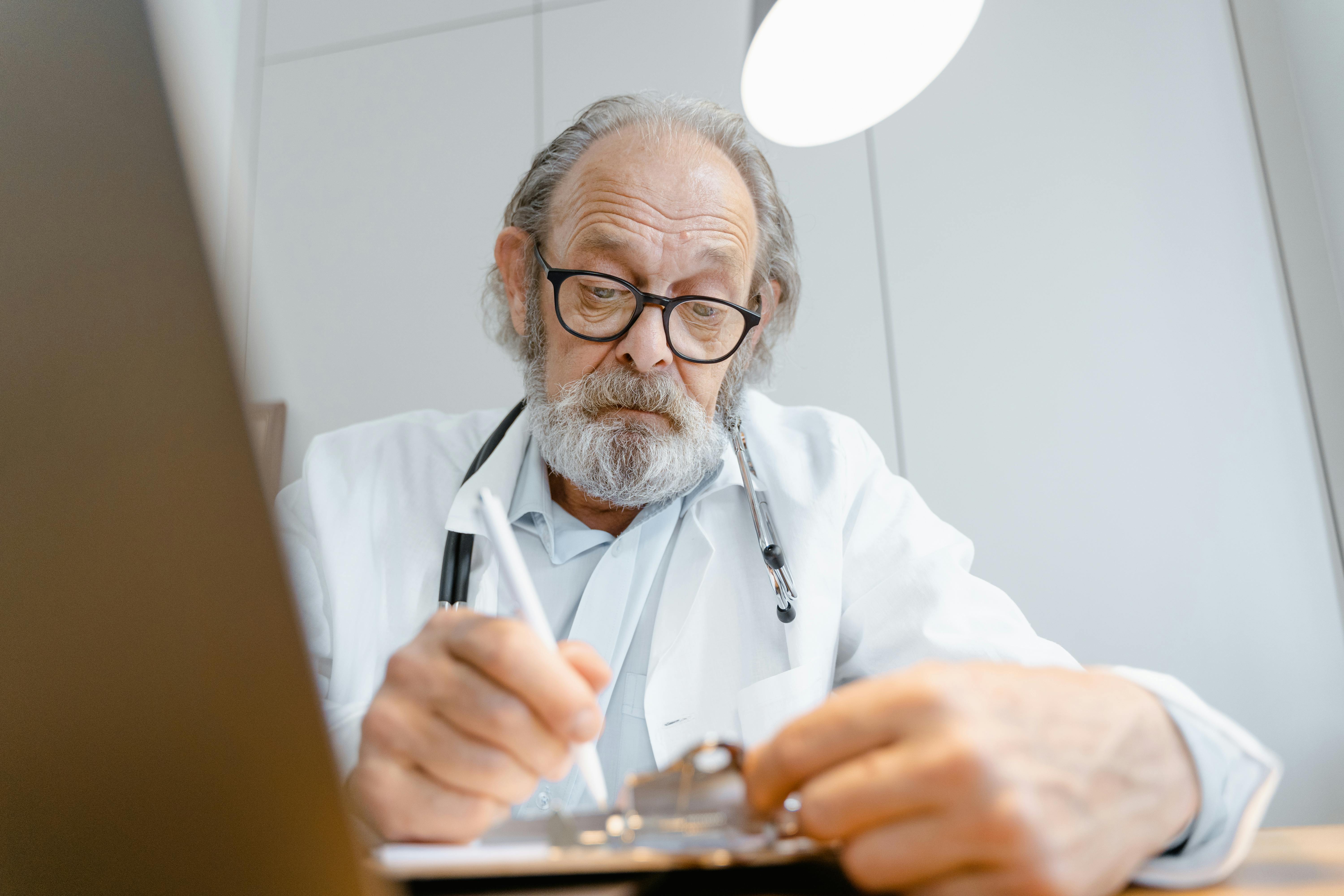 man in white dress shirt wearing eyeglasses holding black pen