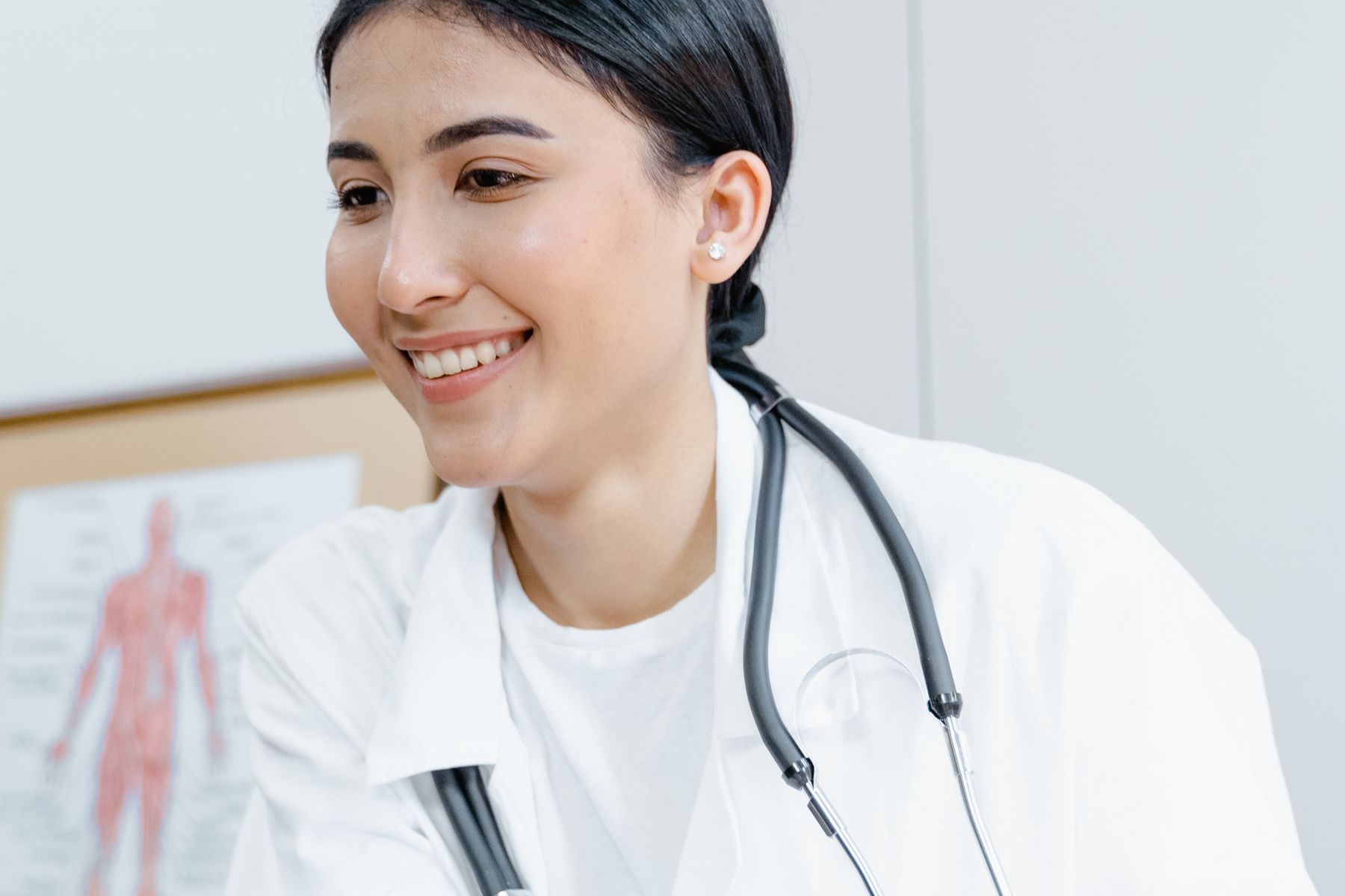 Smiling doctor using a laptop in a bright office