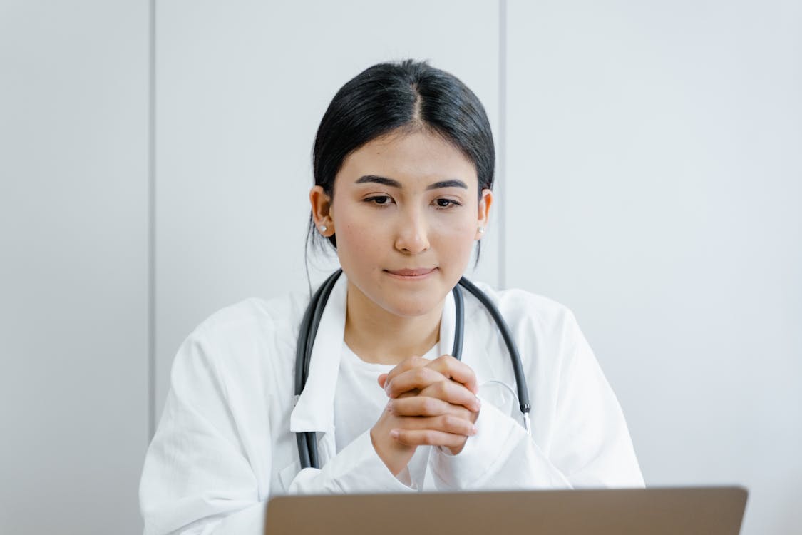 Free Woman in White Scrub Suit Wearing Black and Gray Stethoscope Stock Photo