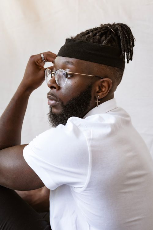Free Elegant side profile of a bearded man wearing glasses and a white shirt, deep in thought. Stock Photo