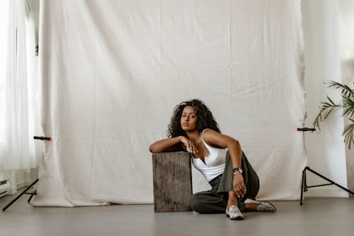 Free A Woman Posing While Sitting on the Floor Stock Photo