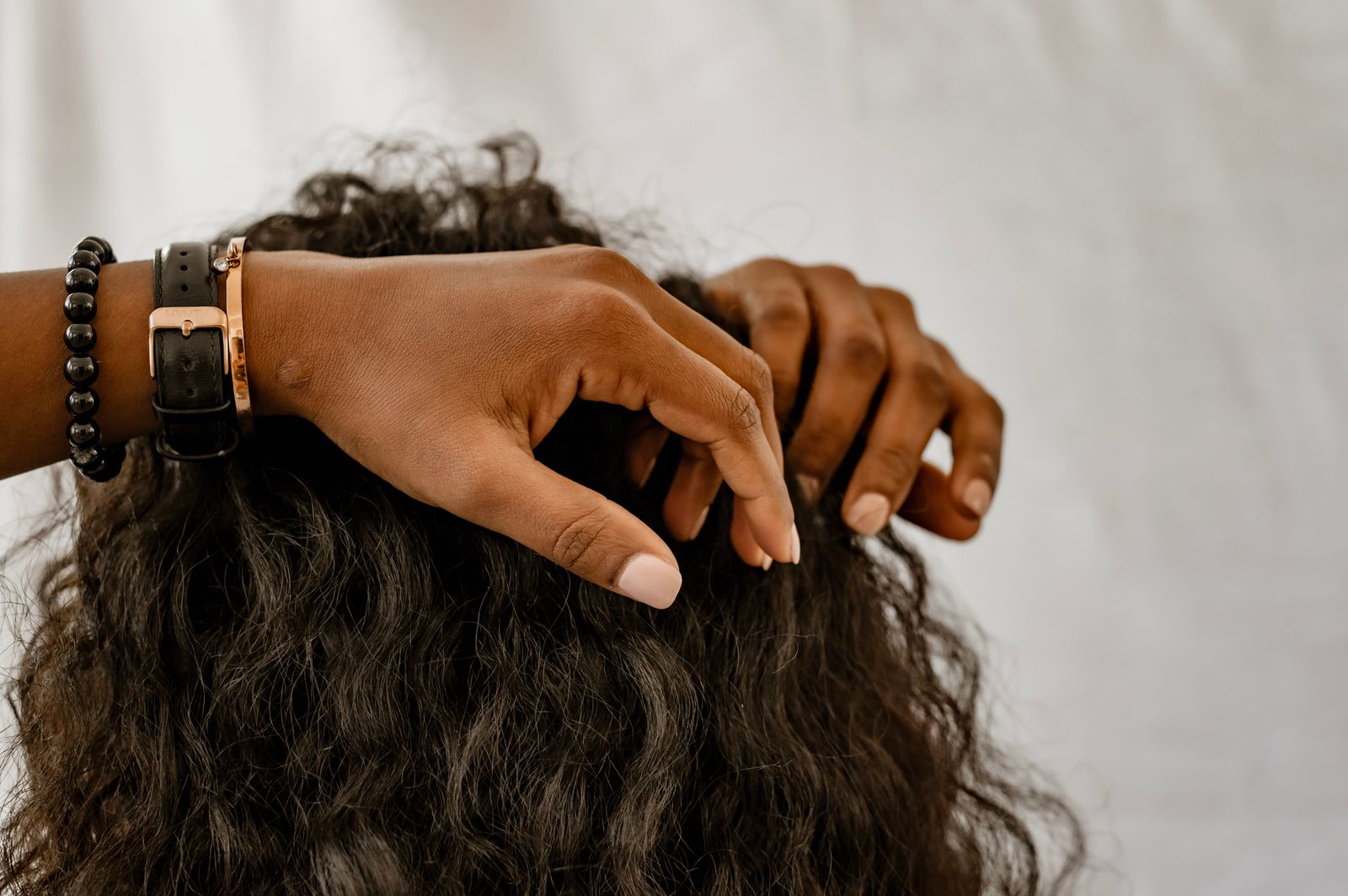 Hands carefully picking through hair — the essential gesture of social grooming