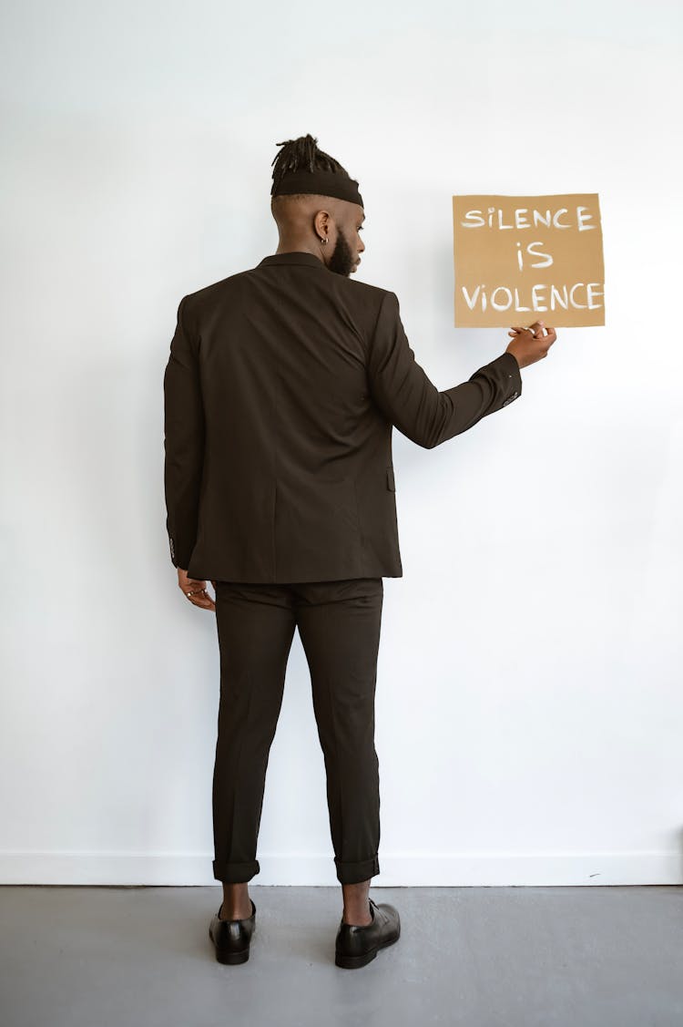 Back View Of A Man Holding A Poster