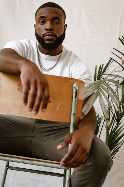 Free Man in White Shirt Sitting on Brown Chair Stock Photo