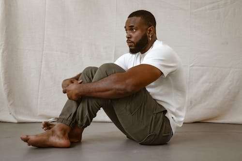 A Man in White Shirt Sitting on the Floor
