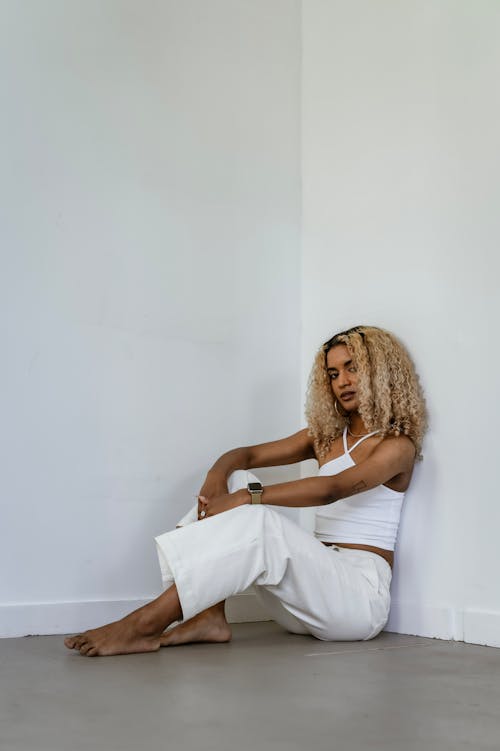 Beautiful Woman in White Clothes Sitting on the Floor