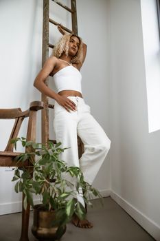 Woman Posing in a Studio Wearing All White Outfit 
