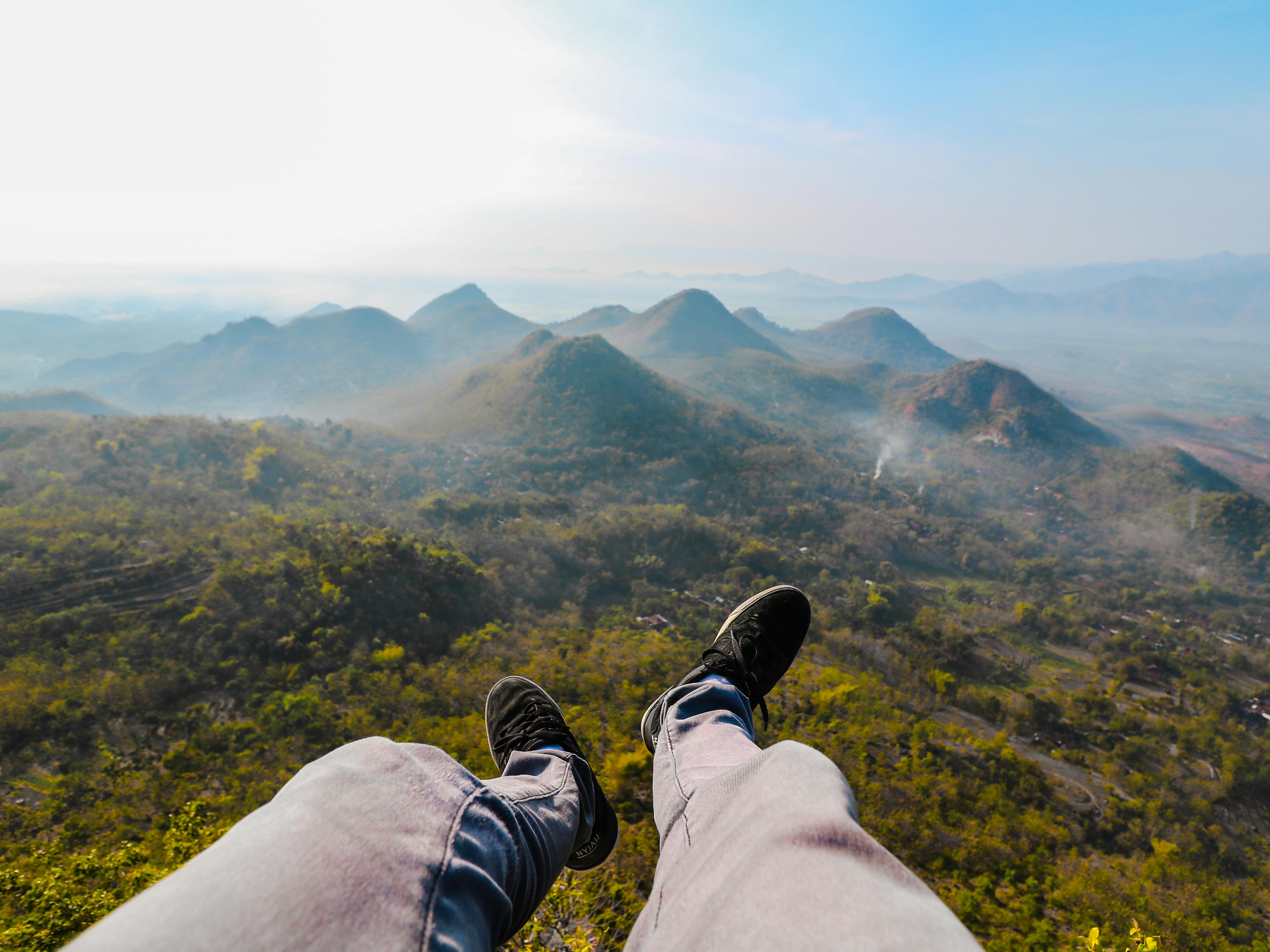 closeup photo of person s foot near mountain