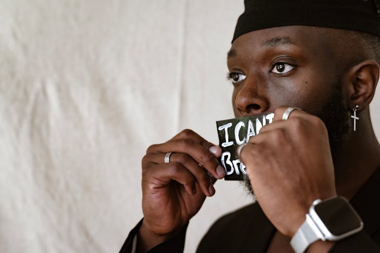 Man Holding Anti Racism Card On Mouth