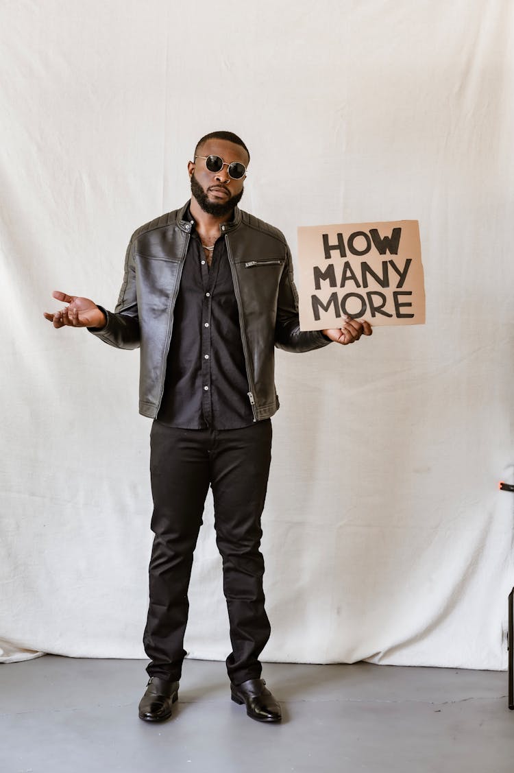 Man In Leather Jacket Holding A Poster