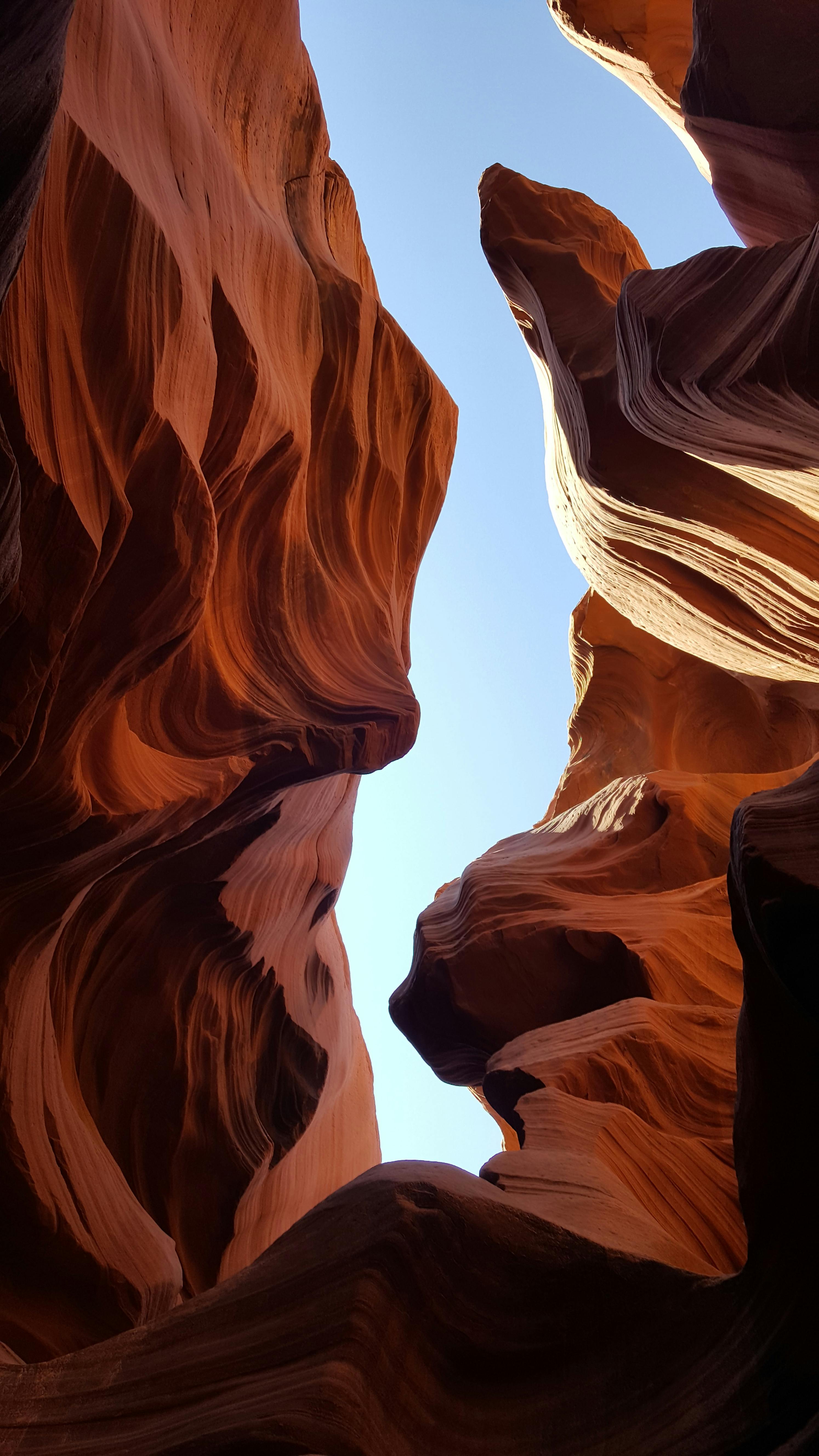 a picturesque view of the stone walls and sky from inside the antelope canyon