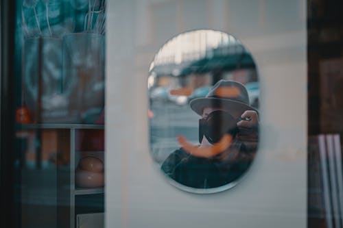 Mirror Shot of a Person Holding a Digital Camera