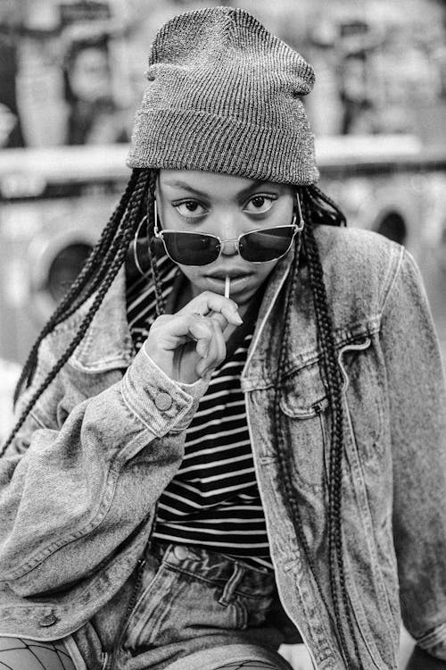 A Woman with Braided Hair Wearing a Beanie while Seriously Looking at the Camera