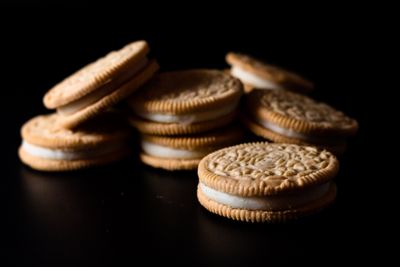 Stack of cream-filled sandwich biscuits on a dark surface — photo by Terrance Barksdale on Pexels