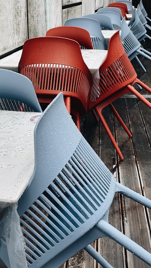 Chairs Leaning Against Tables on a Patio During Rain