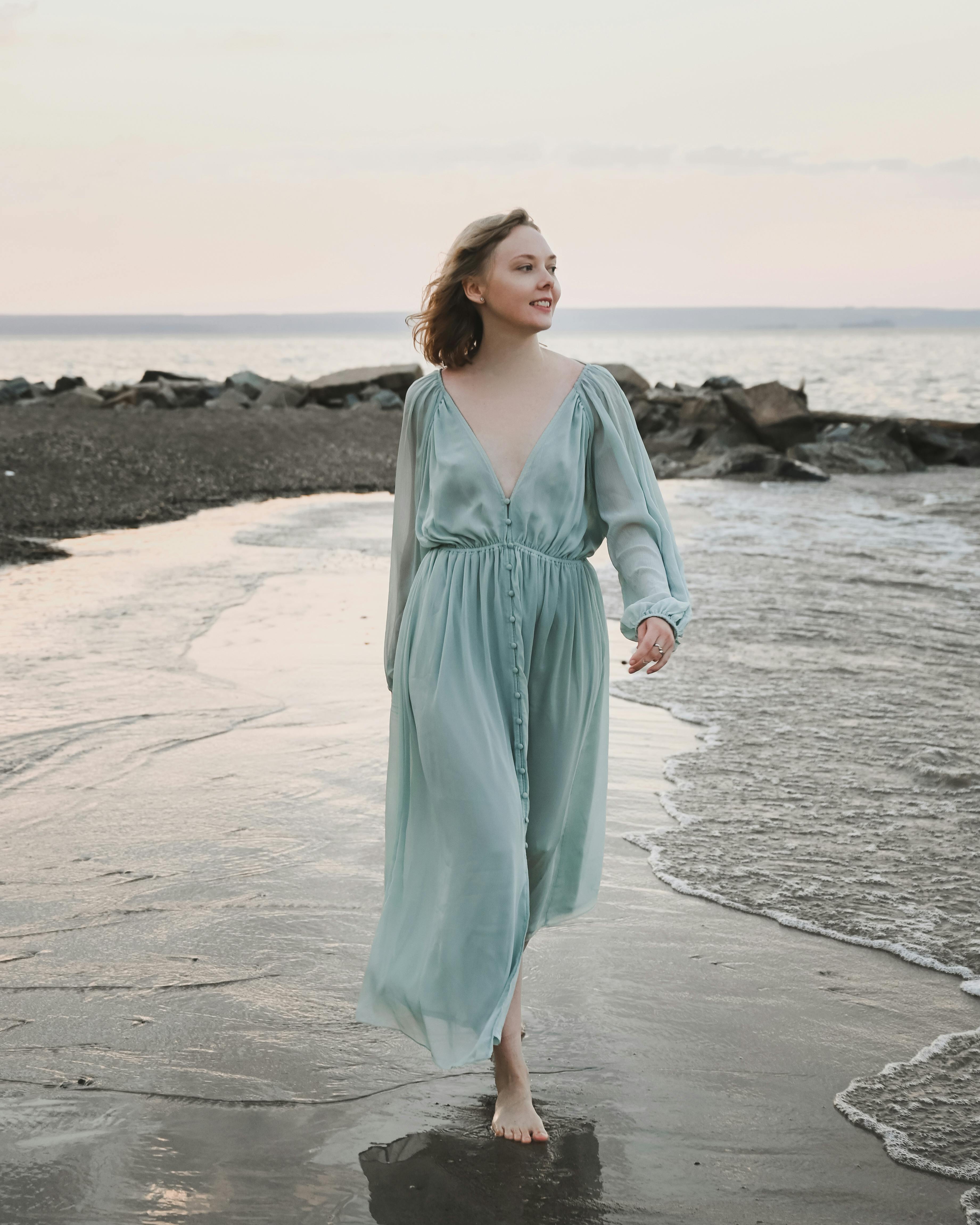 Woman in long dress walking on beach · Free Stock Photo