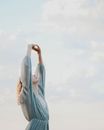 Unrecognizable woman standing against cloudy sky