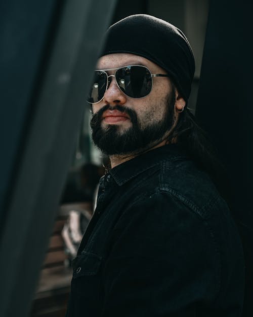 Bearded man in black sunglasses and hat
