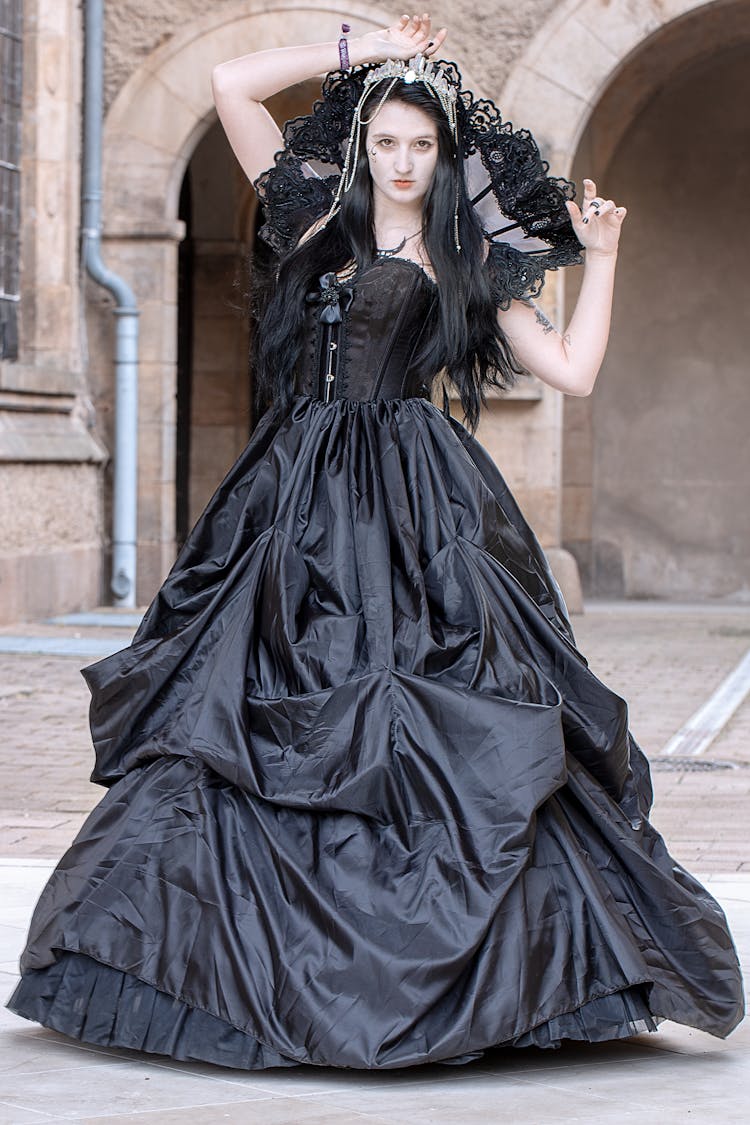 A Woman In Black Ball Gown Seriously Looking At The Camera