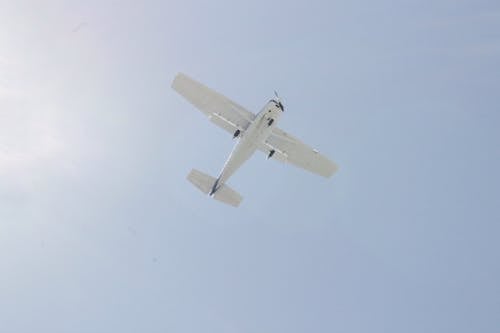 White Cessna Plane Flying Under Blue Sky