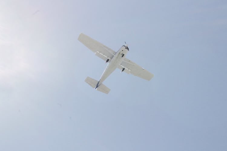 White Cessna Plane Flying Under Blue Sky