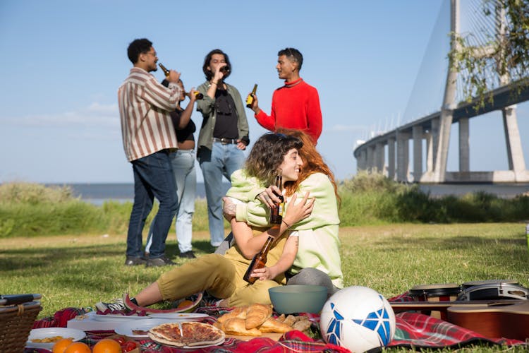 Group Of Friends Having A Picnic At The Vasco Da Gama Bridge In Lisbon