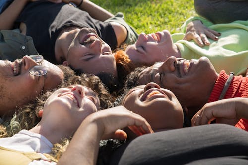 Happy Friends Lying on a Grass Field Together