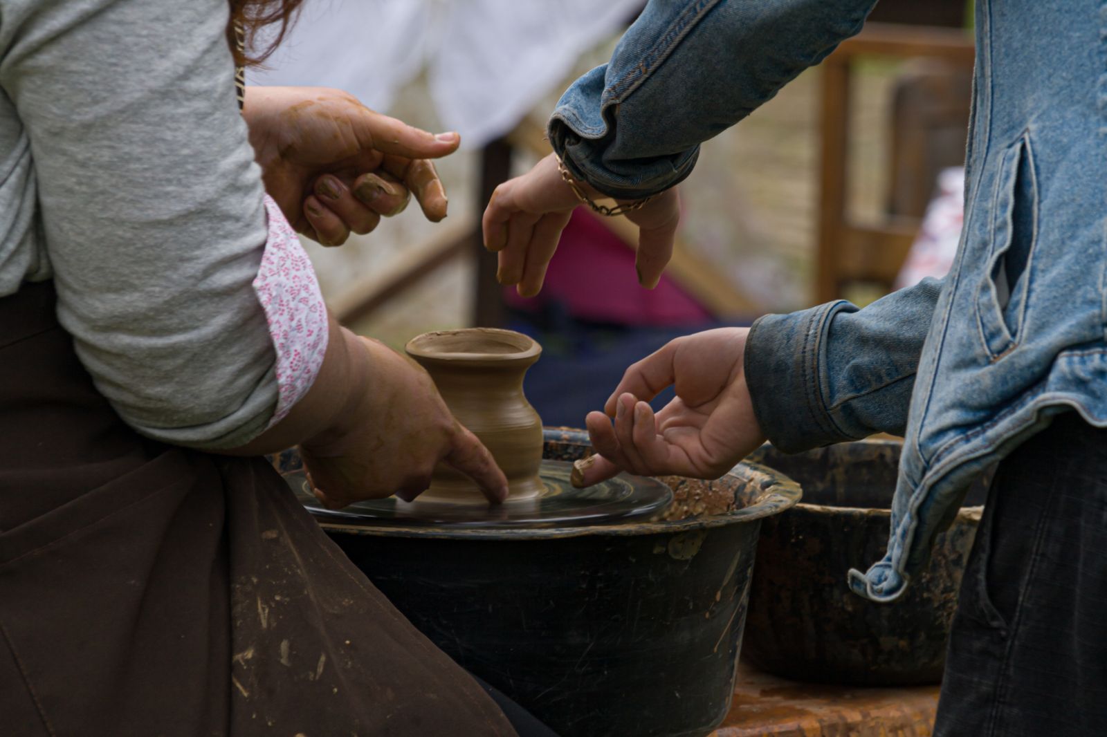 Hands exploring a clay shape together