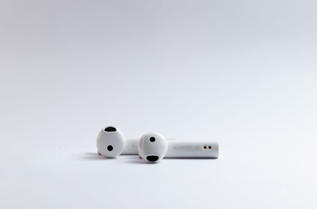 White true-wireless earbuds on a clean white background — photo by Saif71.com on Pexels