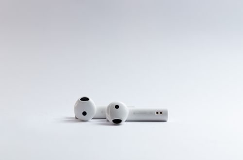 Free Close-up of white wireless earphones on a clean white background, ideal for tech and lifestyle concepts. Stock Photo