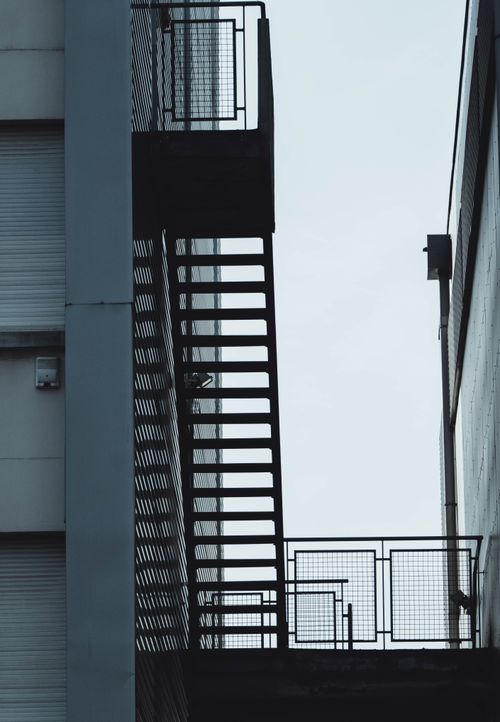 Free Vertical low angle shot of a metal fire escape staircase with railings. Stock Photo
