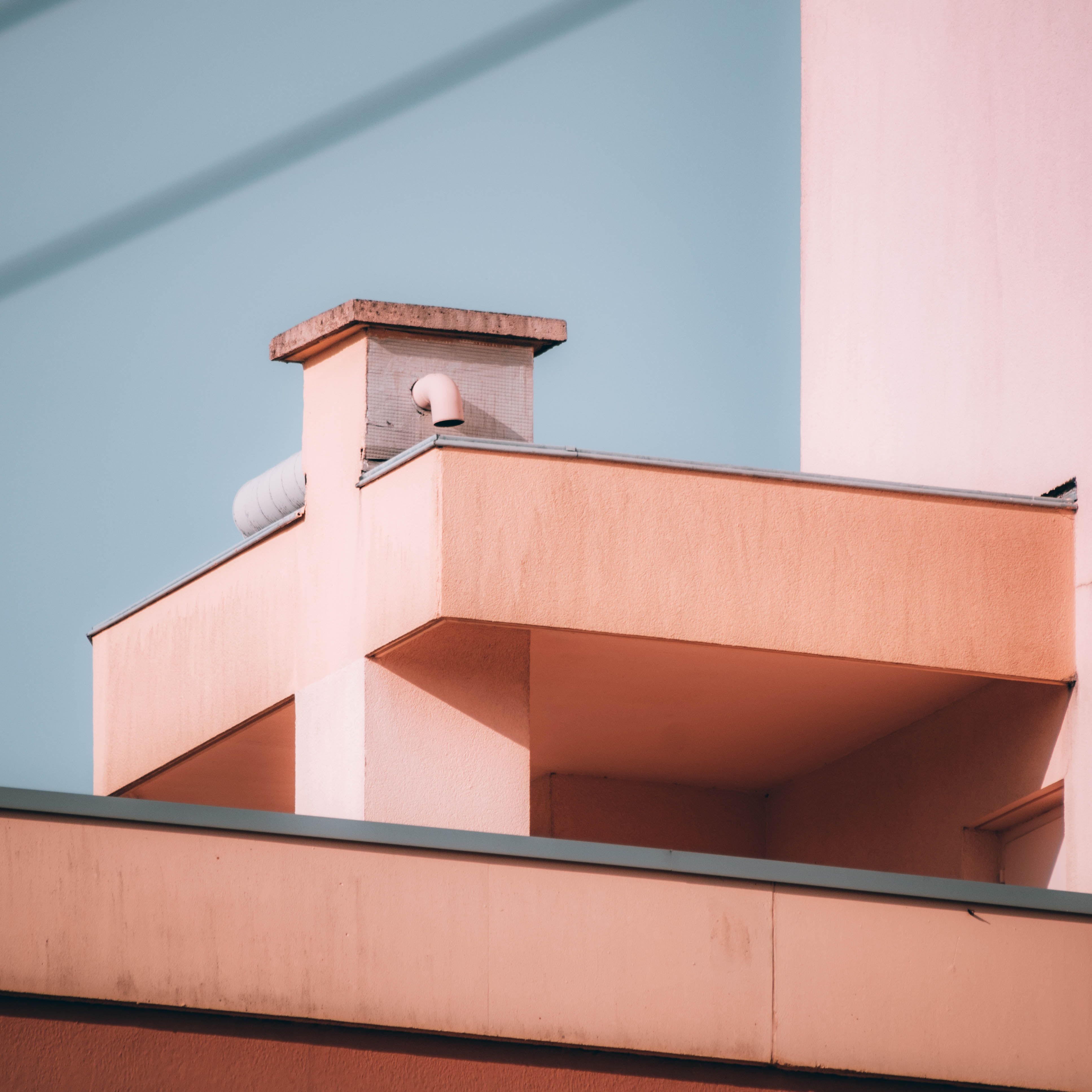 Abstract view of a minimalist building exterior featuring clean lines and soft pastel colors.