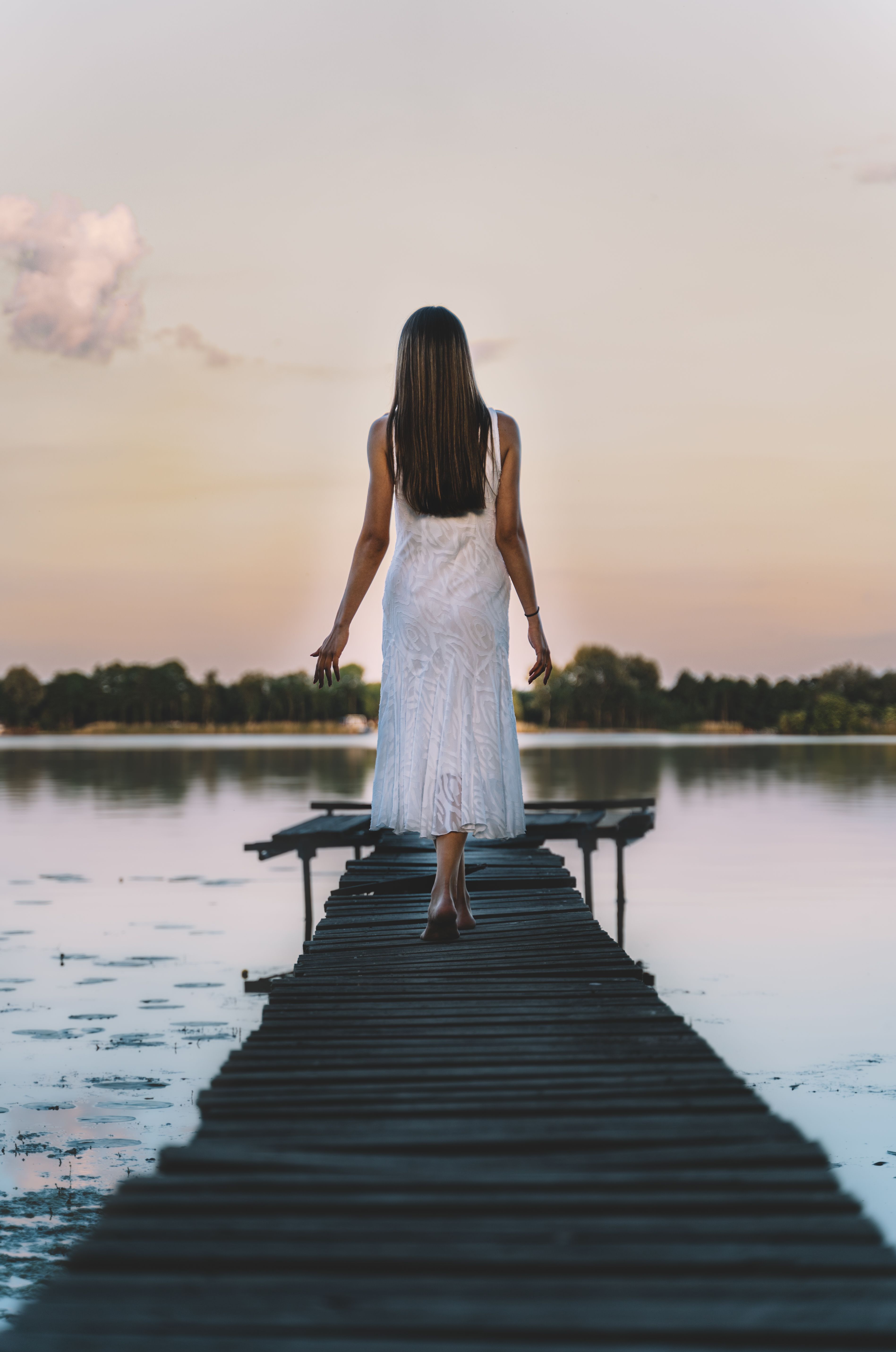 A Woman Wearing White Dress Walking on a Dock · Free Stock Photo