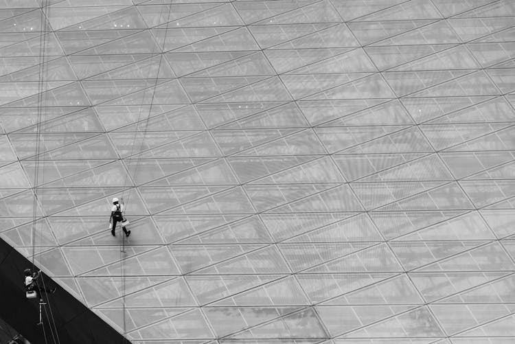 Men Cleaning Windows Of A High Rise Building