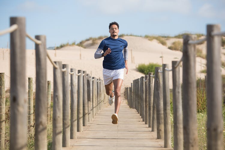 A Man Running On The Wooden Footpath