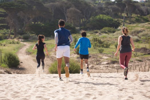 Active group running uphill on a sandy trail in Portugal, showcasing health and fitness outdoors.