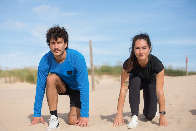 Man And Woman Kneeling On White Sand