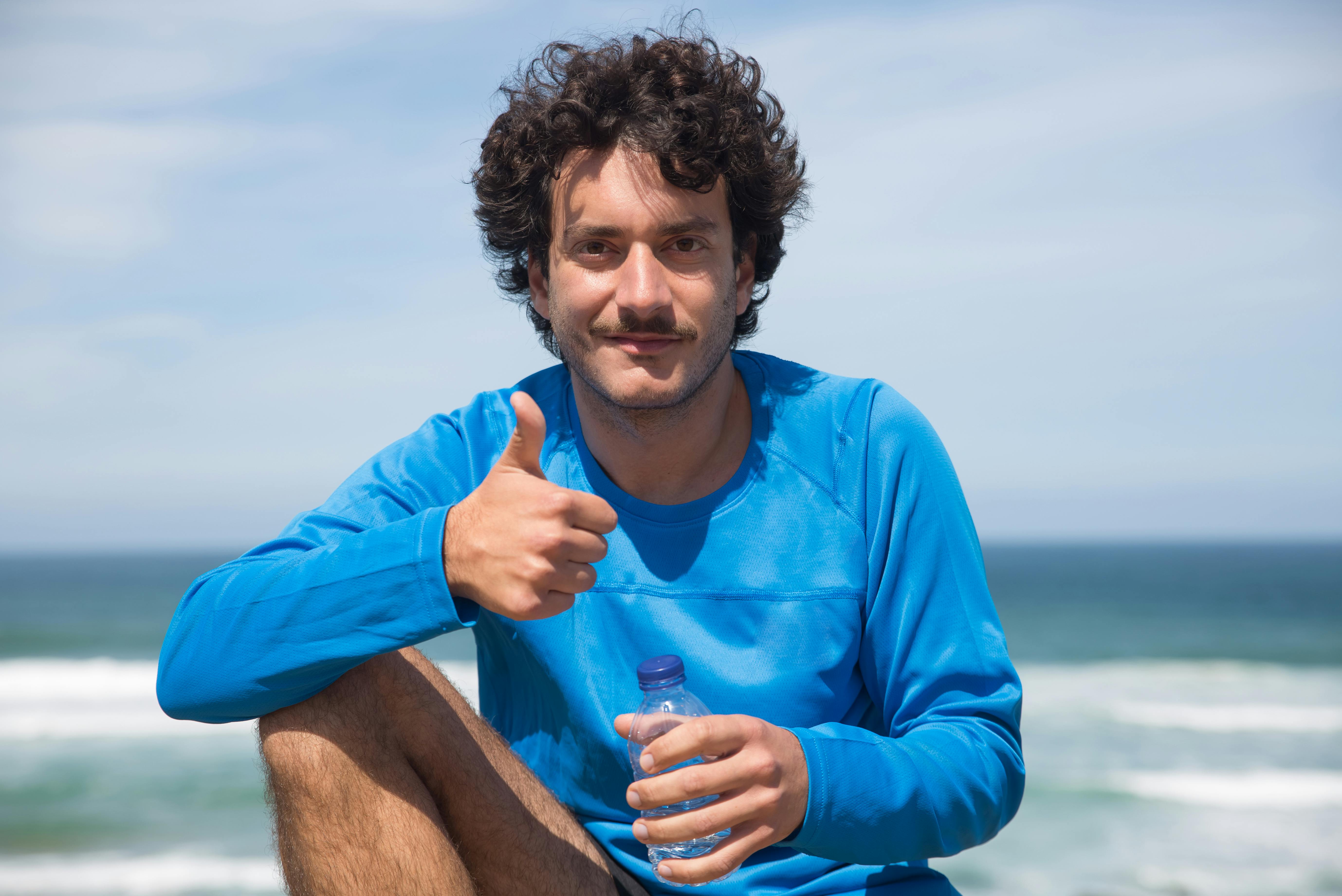 a man in blue long sleeves shirt with the thumbs up sign