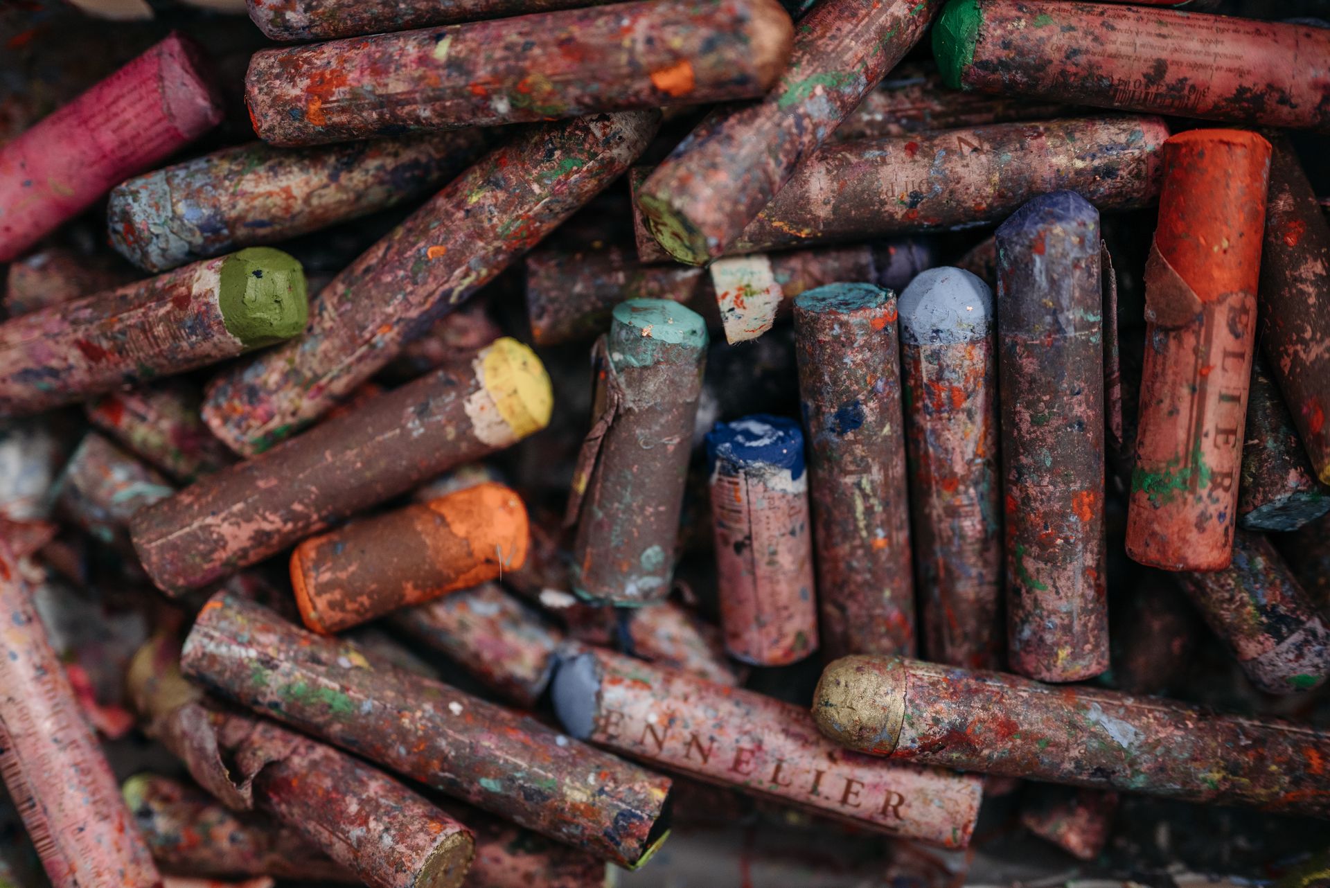 Close-up of a pile of used, colorful oil pastels showcasing art materials and creativity.