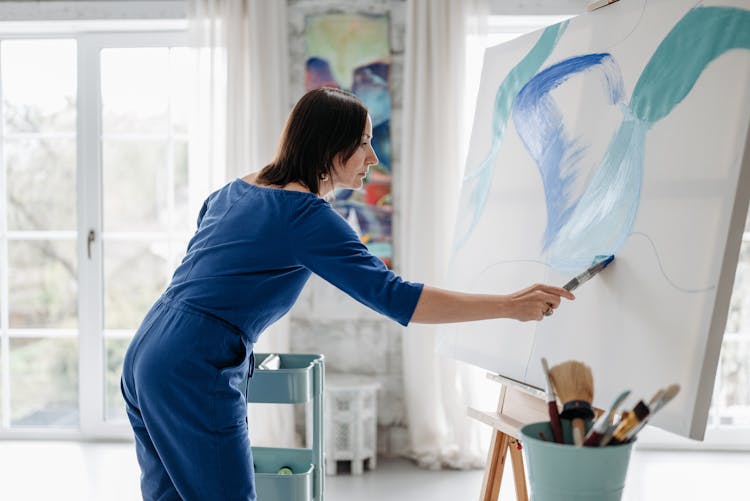 A Woman Painting On White Canvass